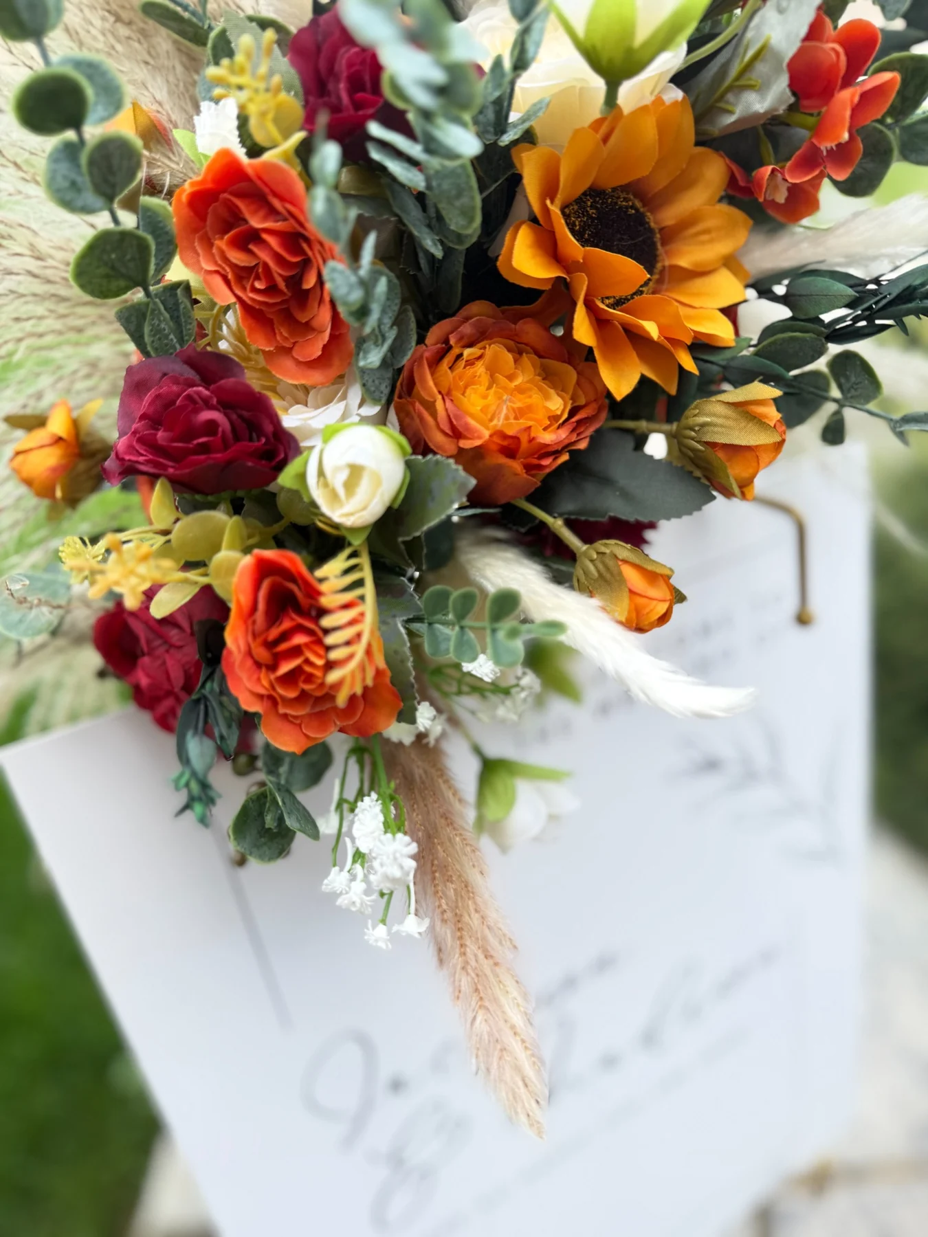 Close-up of orange burgundy and ivory easel florals