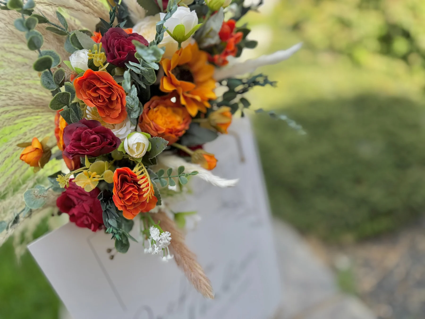 Close-up of styled easel florals and wedding sign