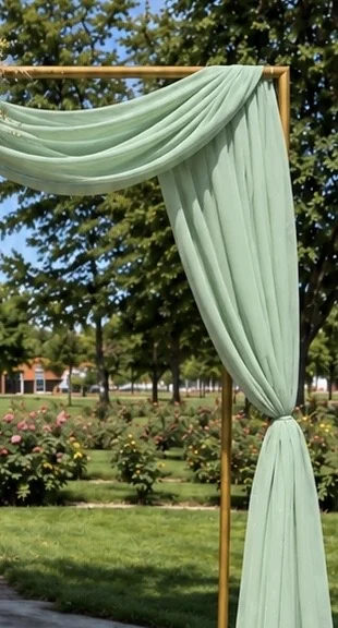 Close-up of sage green draping on the gold square arch
